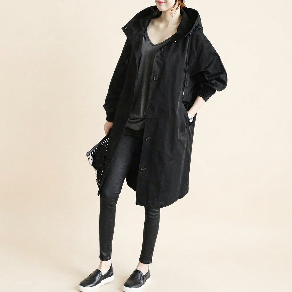 Front view of the Angelika oversized hooded trench coat in black, featuring a relaxed oversized silhouette, attached hood, long sleeves, and practical front pockets.