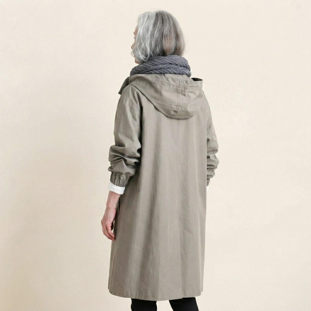 Back side view of the Angelika oversized hooded trench coat in grey, highlighting the relaxed silhouette, attached hood, long sleeves, and clean back design.