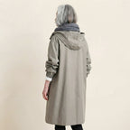 Back side view of the Angelika oversized hooded trench coat in grey, highlighting the relaxed silhouette, attached hood, long sleeves, and clean back design.