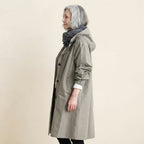 Side view of the Angelika oversized hooded trench coat in grey, showcasing its relaxed oversized silhouette, attached hood, long sleeves, and comfortable layered fit.