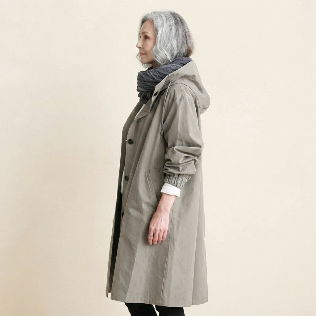 Side view of the Angelika oversized hooded trench coat in grey, showcasing its relaxed oversized silhouette, attached hood, long sleeves, and comfortable layered fit.