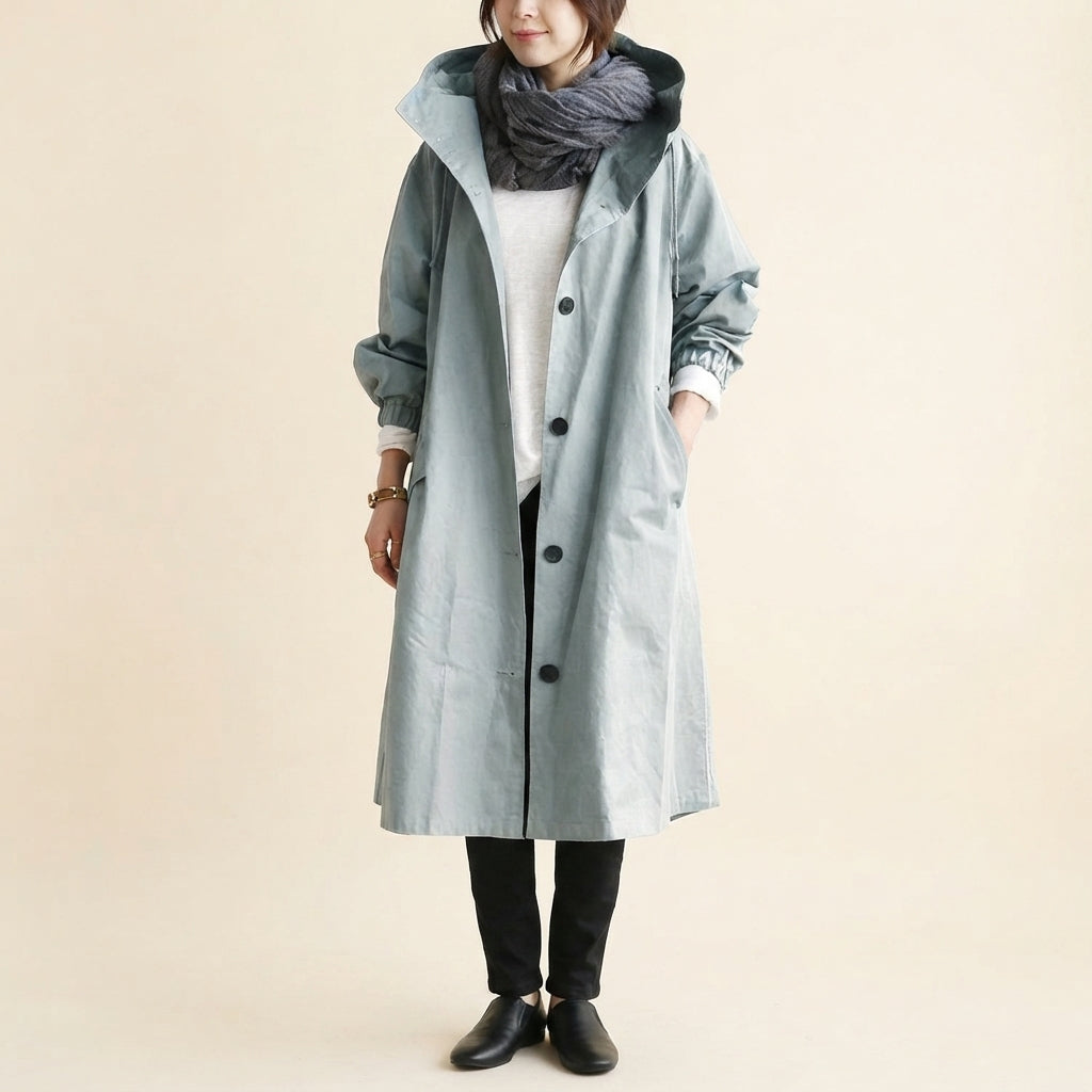 Front view of the Angelika oversized hooded trench coat in light grey, featuring a relaxed oversized silhouette, attached hood, long sleeves, and practical front pockets.