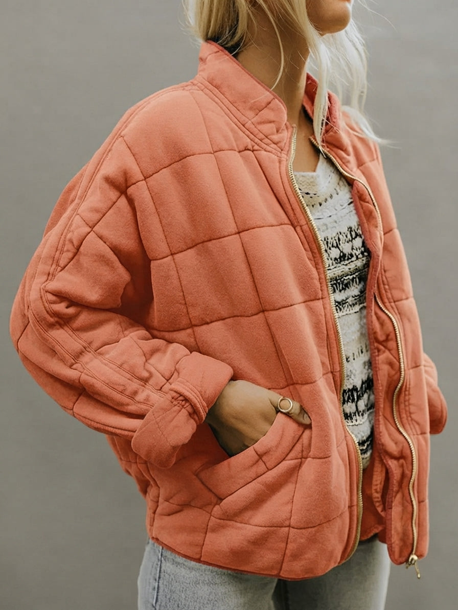 Front view of the Anouska Quilted Jacket in orange, showcasing its quilted texture, oversized relaxed fit, long sleeves, and stylish front design.