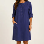 Front view of brightblue linen midi dress with rolled sleeves and side pockets by BELLA HUDSON