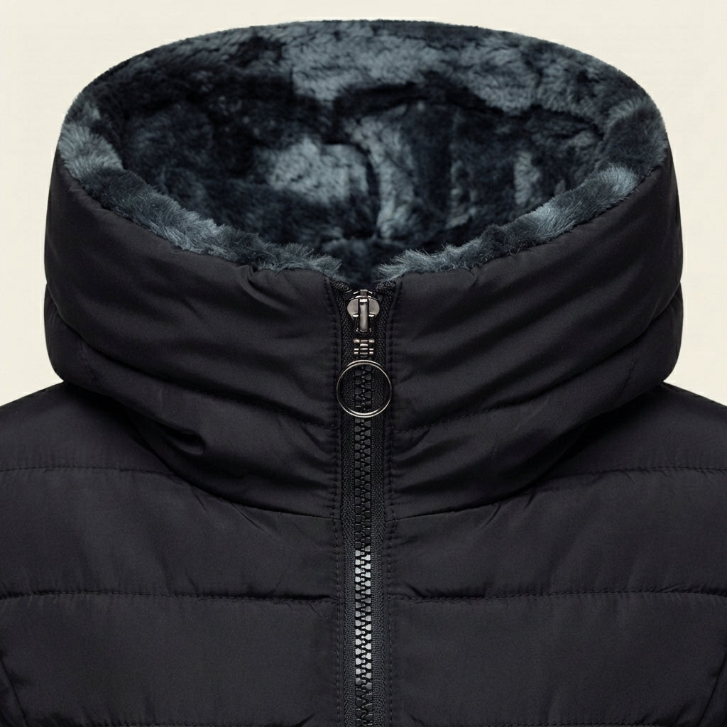 Close-up front view highlighting the Clara puffer jacket’s soft faux-fur-lined hood, quilted texture, full-zip closure, stitching details, and warm black finish.