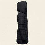 Side view showcasing the Clara puffer jacket in black, highlighting its quilted construction, faux-fur-lined hood, long sleeves, comfortable silhouette, and warm winter-ready design.