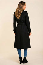 Back side view highlighting the black wool-blend fabric, structured trench coat shape, long sleeves, defined waist, and clean back detailing.