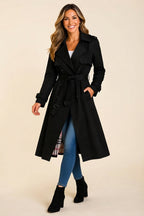 Front-facing view showcasing the black color, structured trench coat silhouette, wool-blend fabric, long sleeves, front closure, and elegant belted waist.