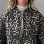 Front close-up of the Odalie Bomber Jacket in dark brown, highlighting the leopard-print pattern, fabric texture, front zip closure, and detailed bomber-style finish.