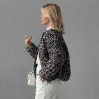 Side view of the Odalie Bomber Jacket in dark brown featuring a bold leopard-print pattern, relaxed bomber silhouette, long sleeves, and comfortable everyday fit.