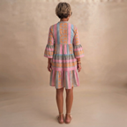 Simone Lightweight Midi Dress in Pink shown in back view featuring a flowing tiered silhouette and long sleeves.