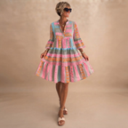 Simone Lightweight Midi Dress in Pink shown in front view with geometric print, tiered skirt, and long sleeves.