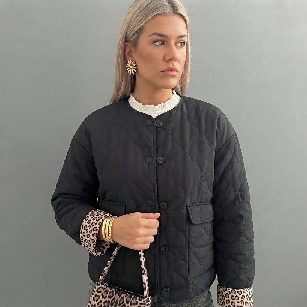 Front close-up of the Sylvaine Jacket Quilted Leopard-Trim in black, highlighting the quilted texture, leopard-print trim, front closure, and detailed finish.