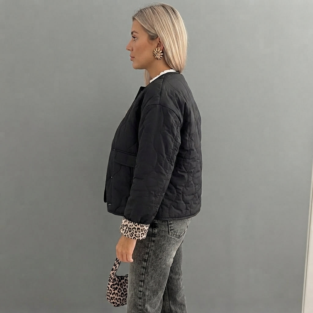 Side view of the Sylvaine Jacket Quilted Leopard-Trim in black, showcasing its quilted texture, leopard-print trim, long sleeves, and stylish comfortable fit.