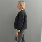 Side view of the Sylvaine Jacket Quilted Leopard-Trim in black, showcasing its quilted texture, leopard-print trim, long sleeves, and stylish comfortable fit.