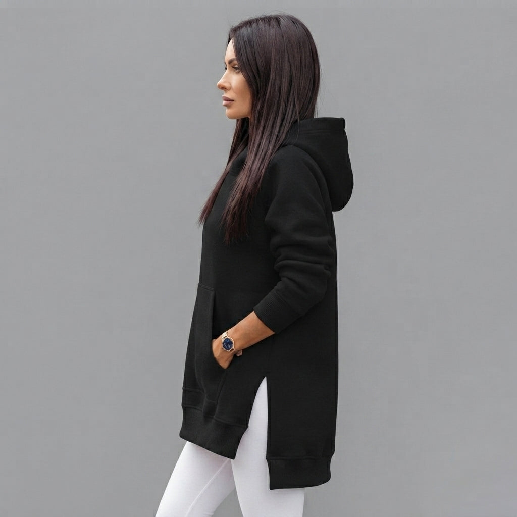 Side view of the Wilhelmine oversized side-slit hoodie in black, showcasing its relaxed silhouette, long sleeves, cozy hood, and side-slit detailing.