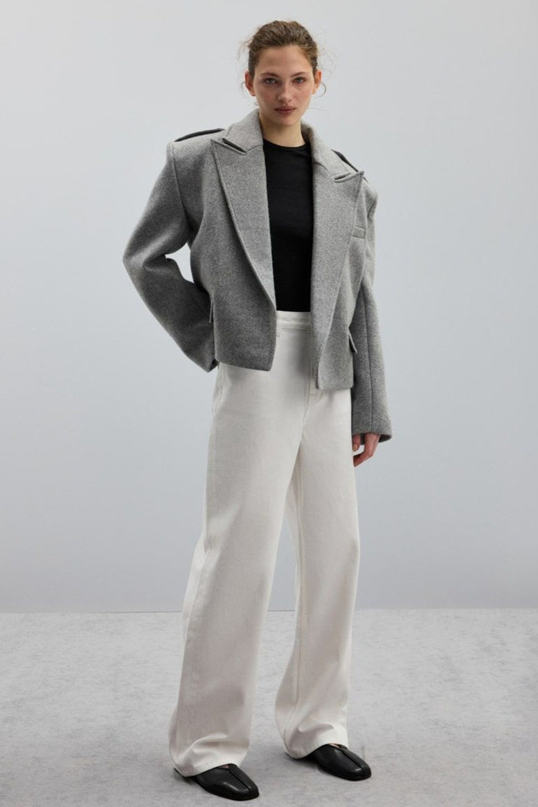 Adele Gray short jacket styled with white wide-leg jeans and black flats.