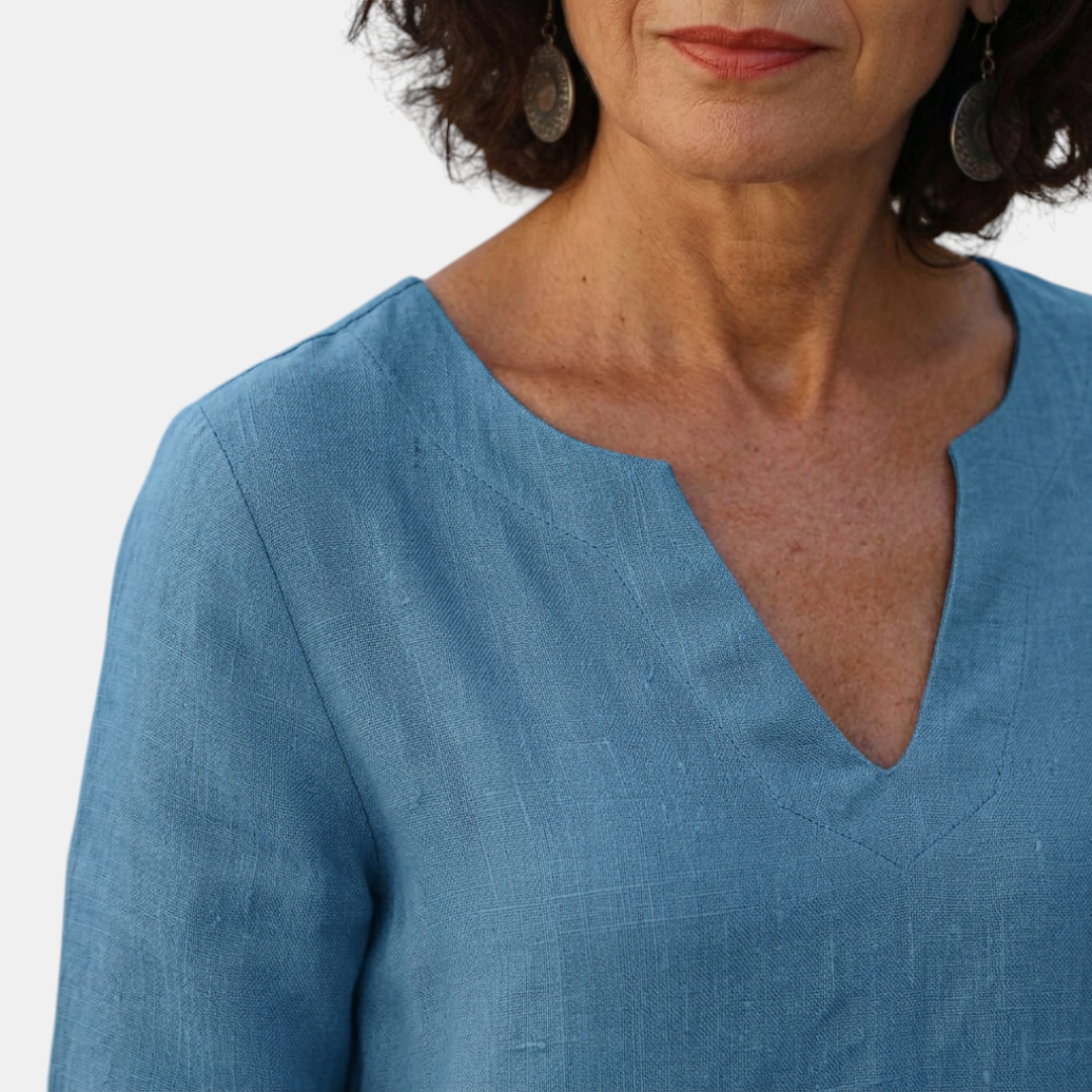 Close-up detail of the Adele Shift Dress Lightweight V-Neck Half-Sleeve in blue, featuring the V-neckline, lightweight textured fabric, and clean minimalist finish. Designed by Bella Hudson.