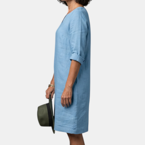 Side view of the Adele Shift Dress Lightweight V-Neck Half-Sleeve in blue, showcasing the relaxed fit, half sleeves, side pockets, and knee-length silhouette. Designed by Bella Hudson.