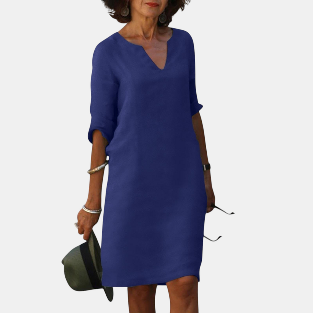 Front view of the Adele Shift Dress Lightweight V-Neck Half-Sleeve in dark blue, featuring a V-neckline, half sleeves, side pockets, and an elegant relaxed silhouette. Designed by Bella Hudson.
