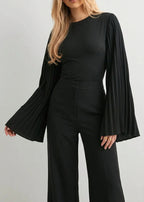 Alina Black top with a crew neckline and pleated flared sleeves, styled with high-waisted black wide-leg pants.