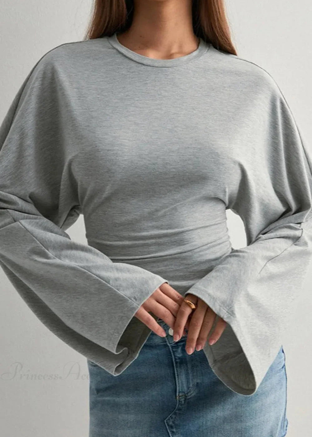 Alina Gray top close-up showing the crewneck, wide flared sleeves and gathered waist ruching with a denim skirt.