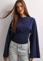 Alina Navy Blue wide-sleeve top with crew neckline and flared sleeves styled with light wash jeans.
