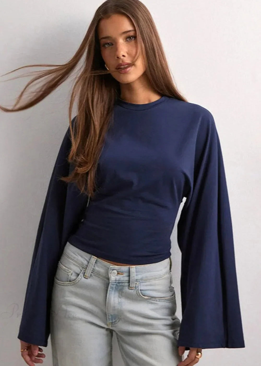 Alina Navy Blue wide-sleeve top with crew neckline and flared sleeves styled with light wash jeans.