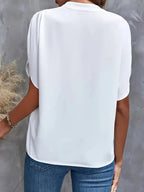 Back detail view of the Amandine Blouse V-Neck Flowy Short-Sleeve in white, highlighting the smooth back panel, relaxed silhouette, and lightweight construction. Designed by Bella Hudson.