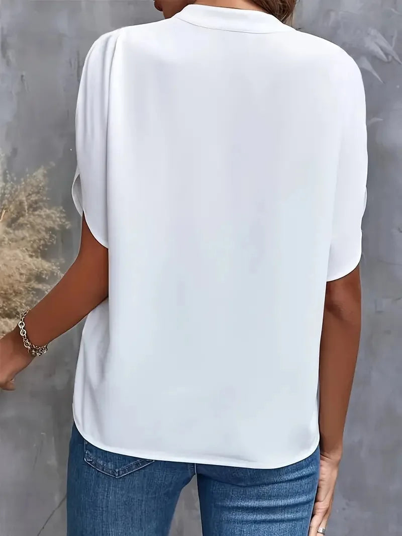 Back detail view of the Amandine Blouse V-Neck Flowy Short-Sleeve in white, highlighting the smooth back panel, relaxed silhouette, and lightweight construction. Designed by Bella Hudson.