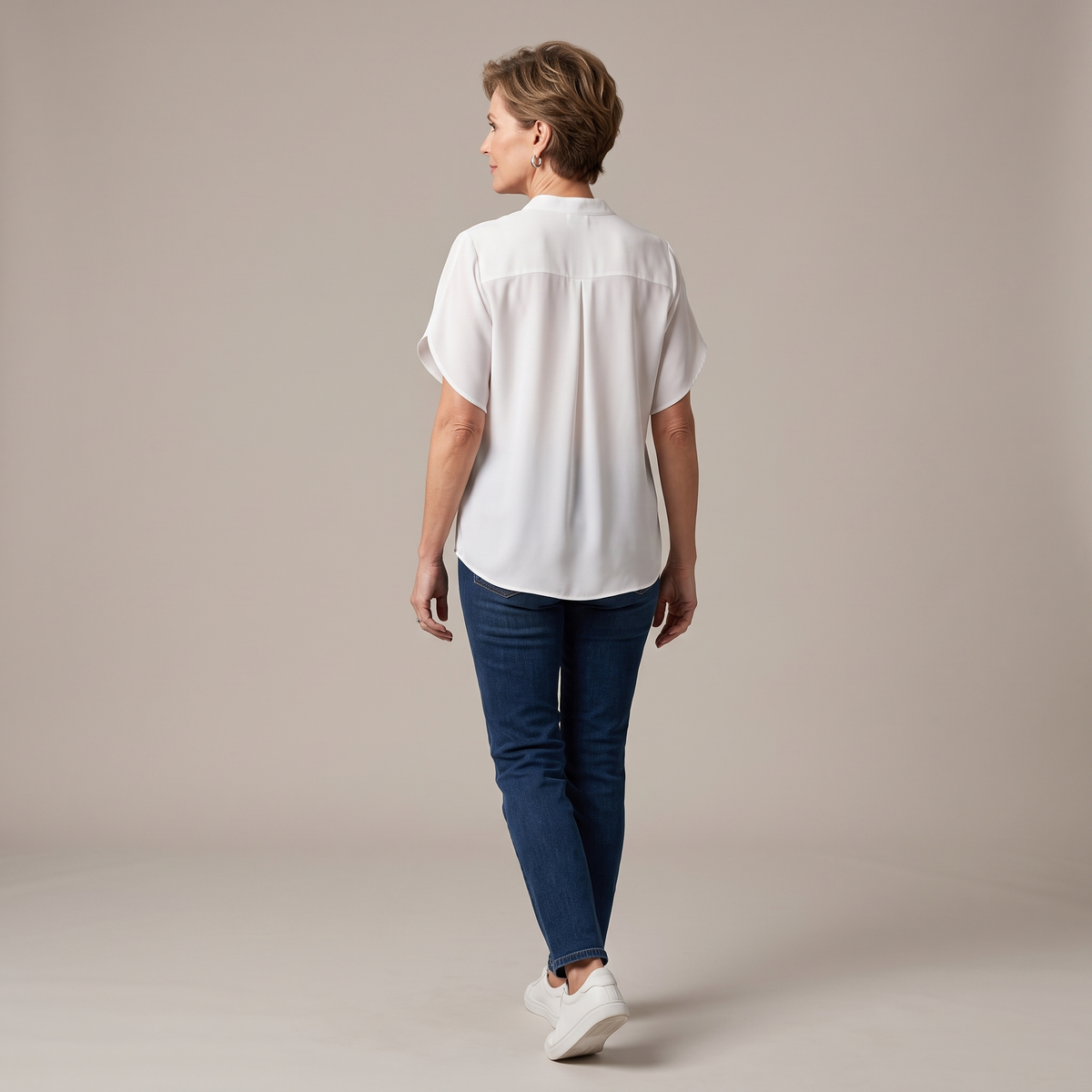 Back view of the Amandine Blouse V-Neck Flowy Short-Sleeve in white, highlighting the relaxed silhouette, lightweight fabric, and clean back design. Designed by Bella Hudson.