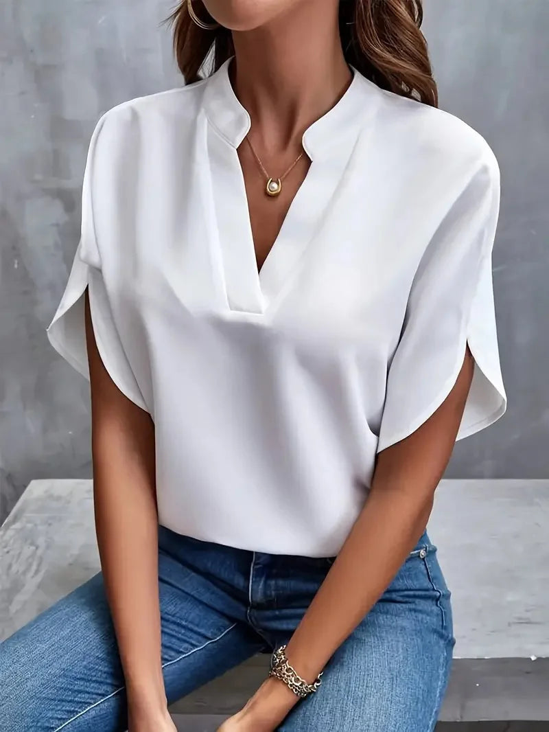 Lifestyle view of the Amandine Blouse V-Neck Flowy Short-Sleeve in white, showcasing the relaxed fit, flowy short sleeves, and effortless everyday styling. Designed by Bella Hudson.
