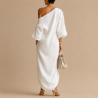 Back view of the Amara Maxi Dress One-Shoulder Linen in white showcasing the relaxed silhouette and elegant asymmetrical design, designed by Bella Hudson.