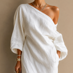 Close-up of the Amara Maxi Dress One-Shoulder Linen in white highlighting the textured linen fabric, one-shoulder neckline, and refined craftsmanship, designed by Bella Hudson.