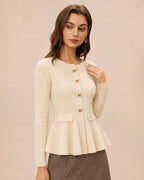 Amelia Beige ribbed knit peplum cardigan shown from a three-quarter angle, highlighting the round neckline, bow buttons and flared hem.
