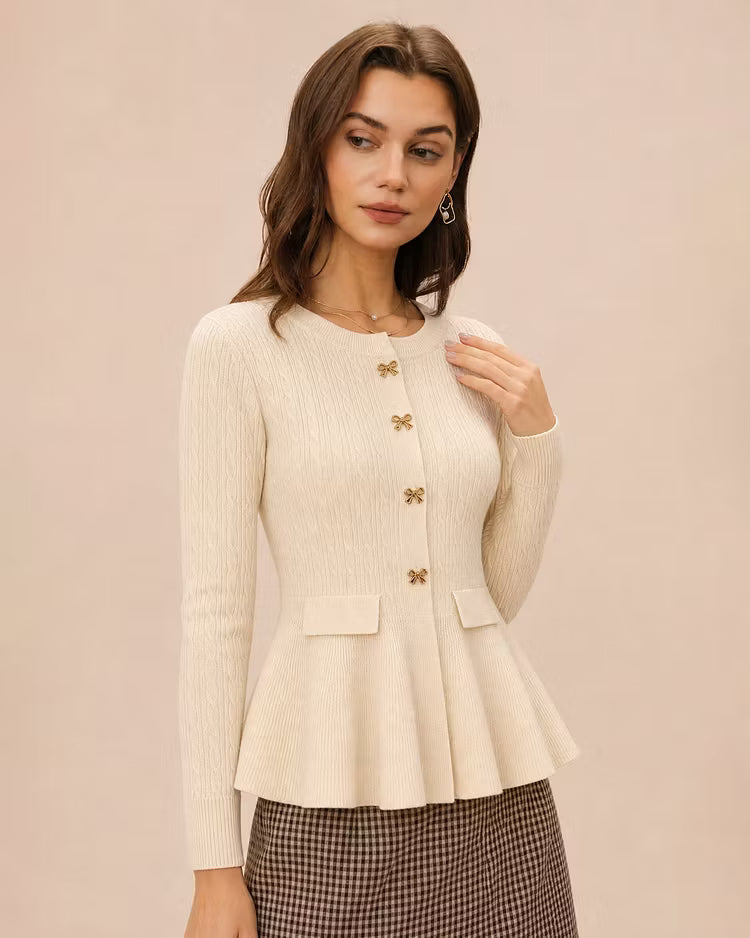 Amelia Beige ribbed knit peplum cardigan shown from a three-quarter angle, highlighting the round neckline, bow buttons and flared hem.