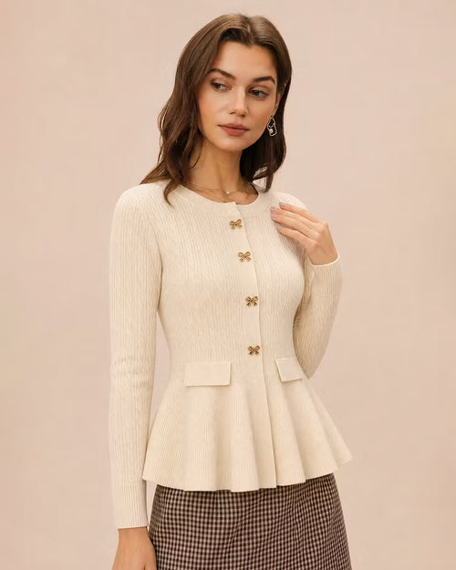 Amelia Beige ribbed knit peplum cardigan shown from a three-quarter angle, highlighting the round neckline, bow buttons and flared hem.