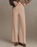 Anwen Khaki high-waisted wide-leg pants shown from the front with patch pockets and a button closure, styled with a knit cardigan.