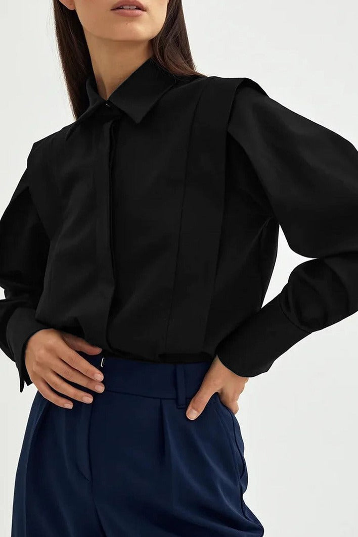 Ariana Black button-down shirt close-up of the concealed button front and structured shoulder, worn with navy trousers.