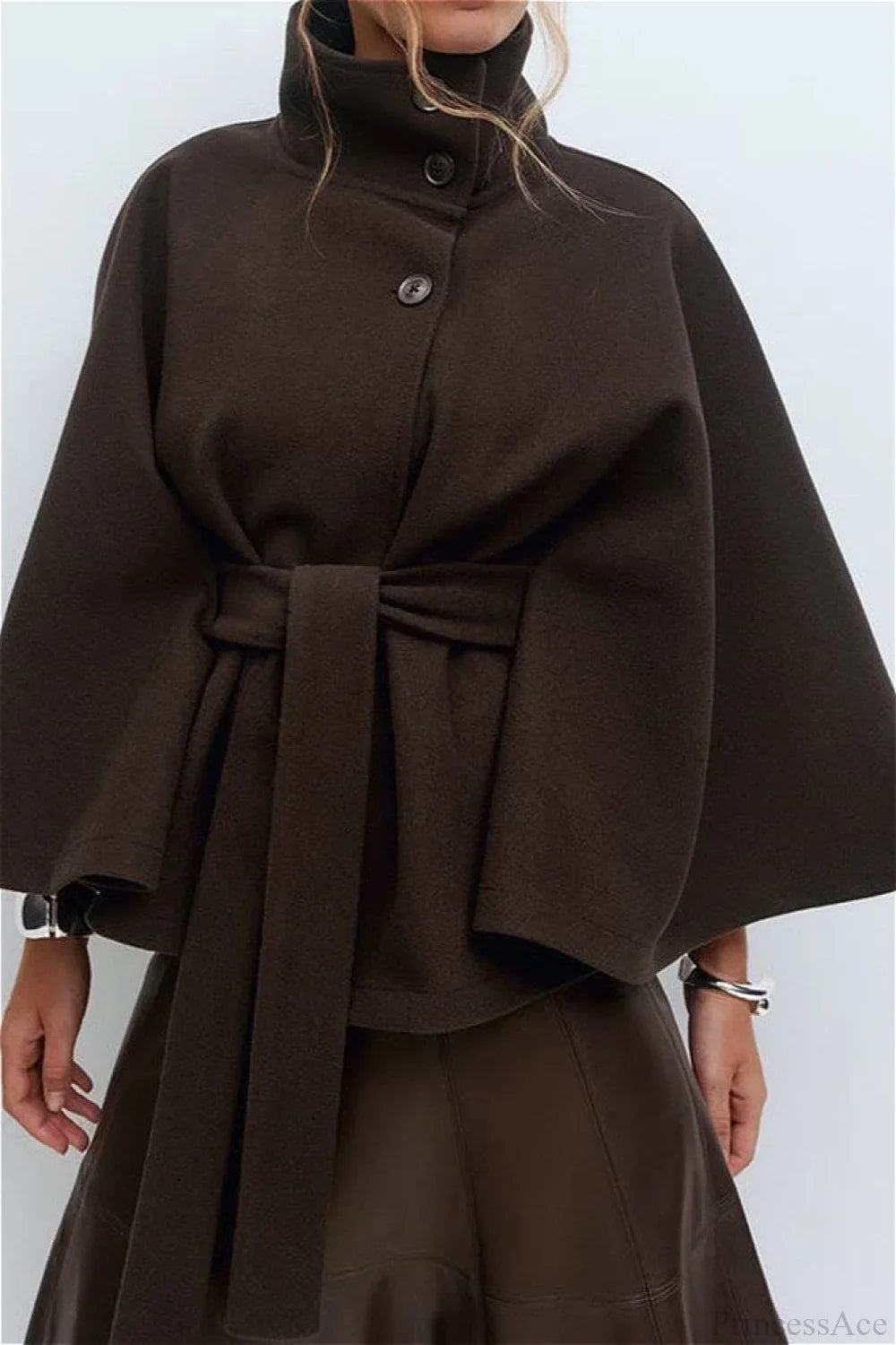 Arielle Brown belted cape jacket styled with a leather skirt, showing the buttoned collar and self-tie belt.