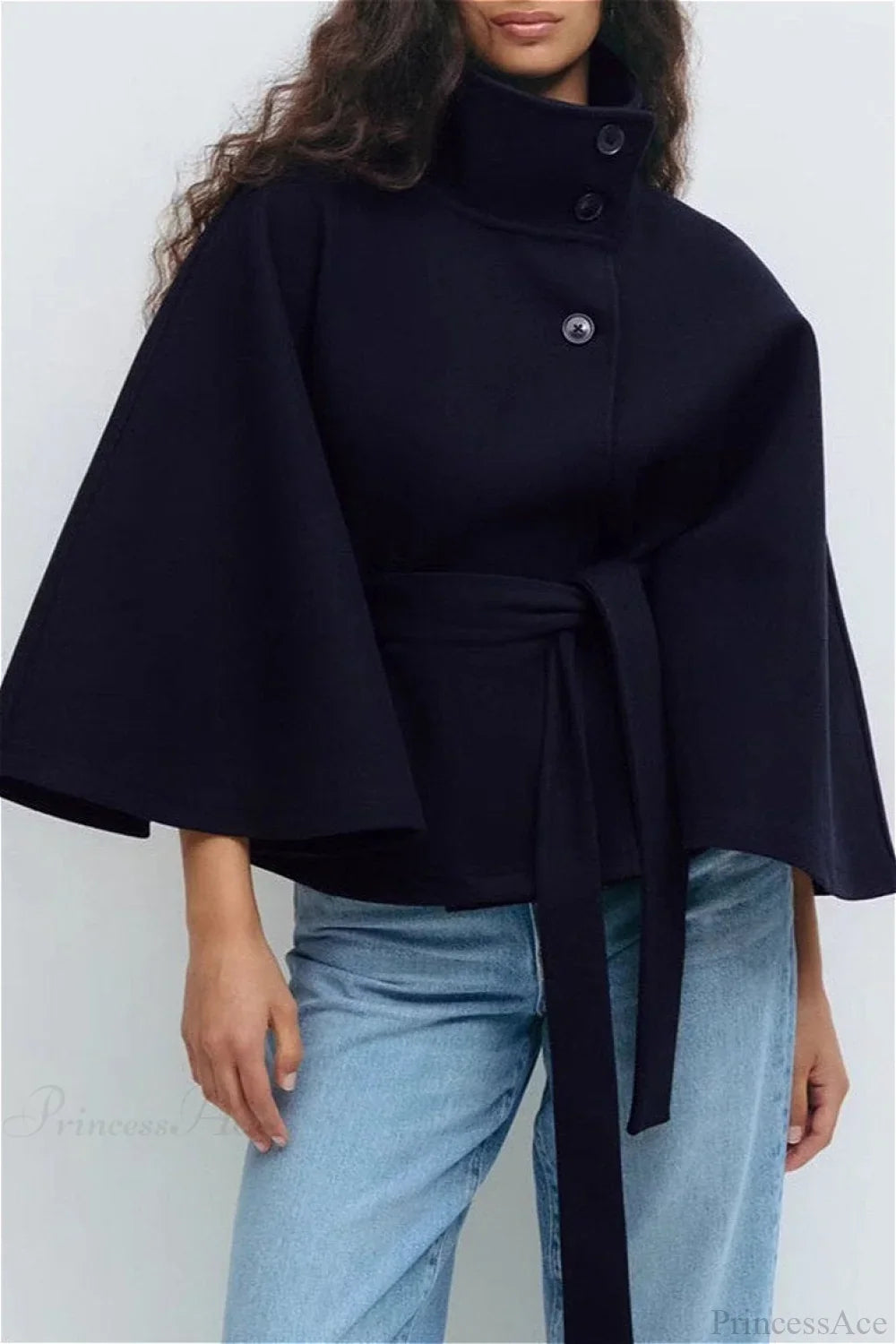 Arielle Navy Blue belted cape jacket styled with light-wash jeans, showing the stand collar, buttons and tied belt.