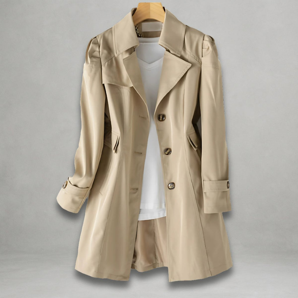 Front view of the Aurora Trench Coat with Belted Notch Collar in khaki, featuring wide notched lapels, a button-front closure, long sleeves with cuff straps, matching waist belt, and a flared mid-length silhouette. Designed by Bella Hudson.