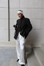 Aveline Black blazer styled full-length with wide-leg white pants and a white headband.