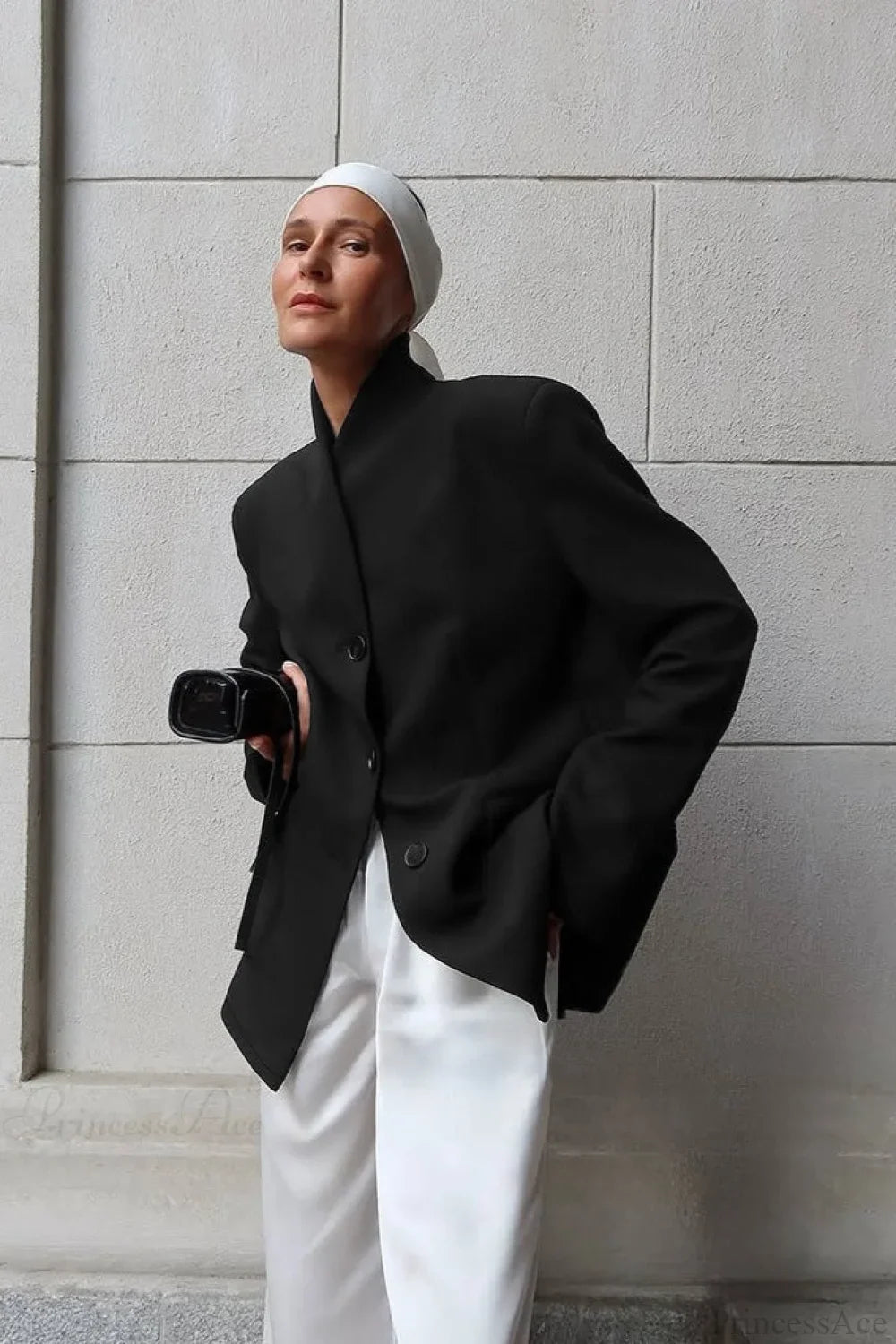 Aveline Black blazer with structured shoulders and relaxed fit, worn with white satin pants.