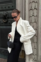 Aveline White blazer showing the stand collar, flap pocket, and relaxed sleeves.