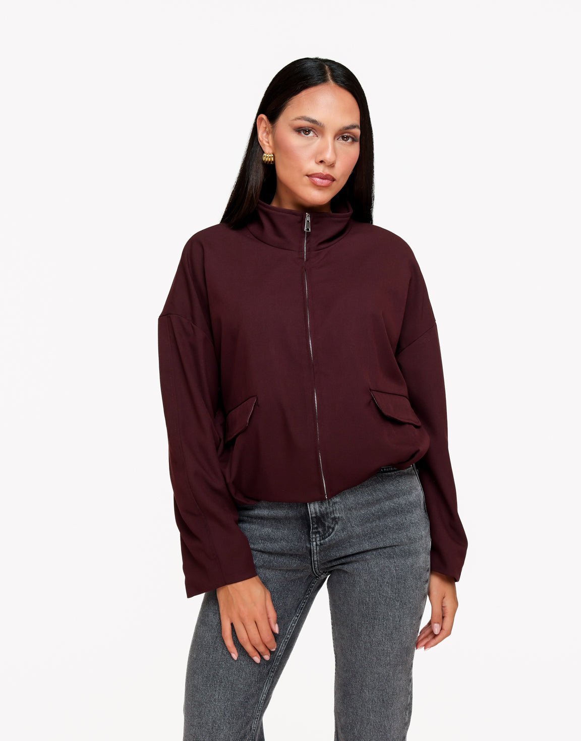 Averil Aubergine bomber jacket styled with gray jeans, showing hip flap pockets and roomy sleeves.