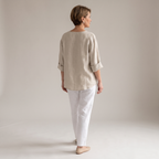 Back view of the Averil Blouse Linen Long-Sleeve in beige, highlighting the relaxed silhouette, long rolled sleeves, and lightweight linen construction. Designed by Bella Hudson.