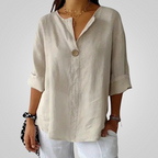 Front detail view of the Averil Blouse Linen Long-Sleeve in beige, showcasing the relaxed fit, rolled sleeves, split neckline, and breathable linen fabric. Designed by Bella Hudson.
