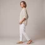 Side view of the Averil Blouse Linen Long-Sleeve in beige, showcasing the relaxed fit, rolled long sleeves, split V-neckline, and breathable linen fabric. Designed by Bella Hudson.