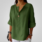 Front view of the Averil Blouse Linen Long-Sleeve in green, featuring a split V-neckline, long rolled sleeves, decorative button detail, and a relaxed breathable linen fit. Designed by Bella Hudson.